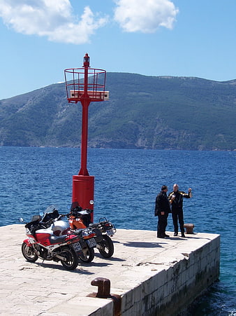 Motorcycles parked at red lighthouse pier in Croatia
