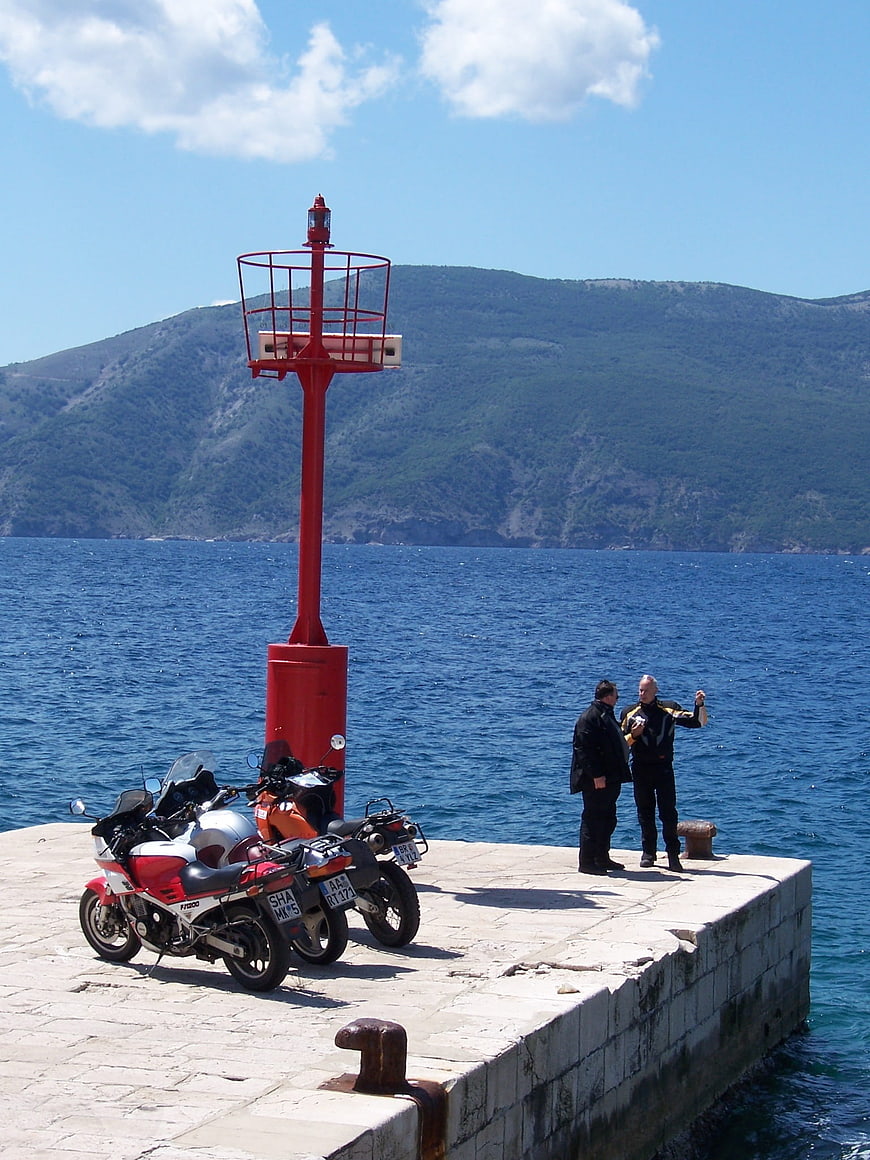 Motorcycles parked at red lighthouse pier in Croatia