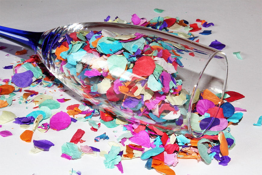 Spilled Multicolored Confetti in Blue Champagne Glass