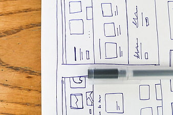 Hand-drawn wireframe sketch on paper with pen
