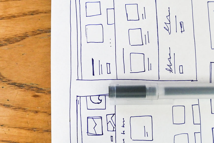 Hand-drawn wireframe sketch on paper with pen
