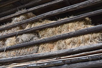 Stacked hay bales in rustic wooden barn interior