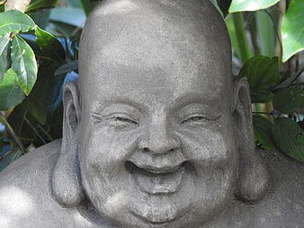 Close-up of smiling stone Buddha statue in garden