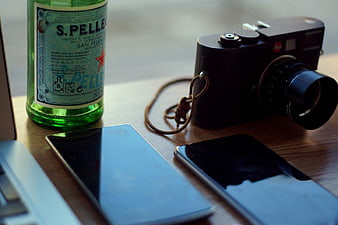 Leica Camera, Smartphones, and S.Pellegrino on Wooden Table