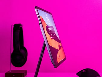 iPad on Stand with Headphones Against Pink Background