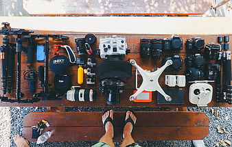 Top-down view of photography gear and drone on wooden bench