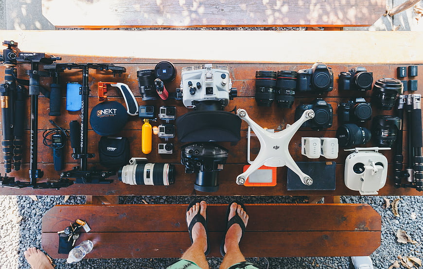 Top-down view of photography gear and drone on wooden bench