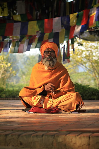 Hindu Sadhu Monk Meditating with Prayer Beads Under Prayer Flags