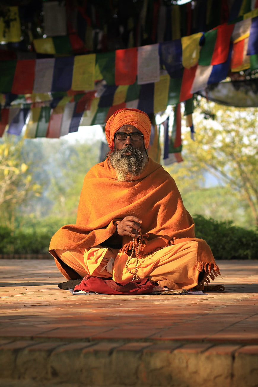 Hindu Sadhu Monk Meditating with Prayer Beads Under Prayer Flags