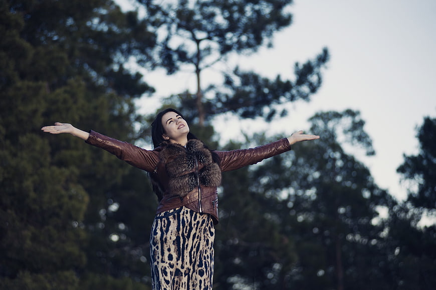 Happy woman with arms open in nature