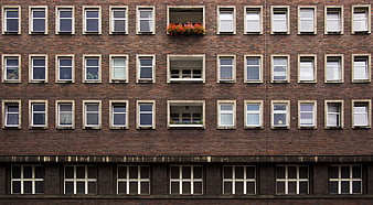 Symmetrical brick apartment building facade with window grid