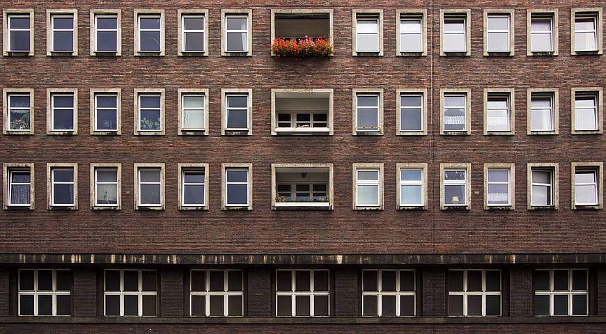 Symmetrical brick apartment building facade with window grid