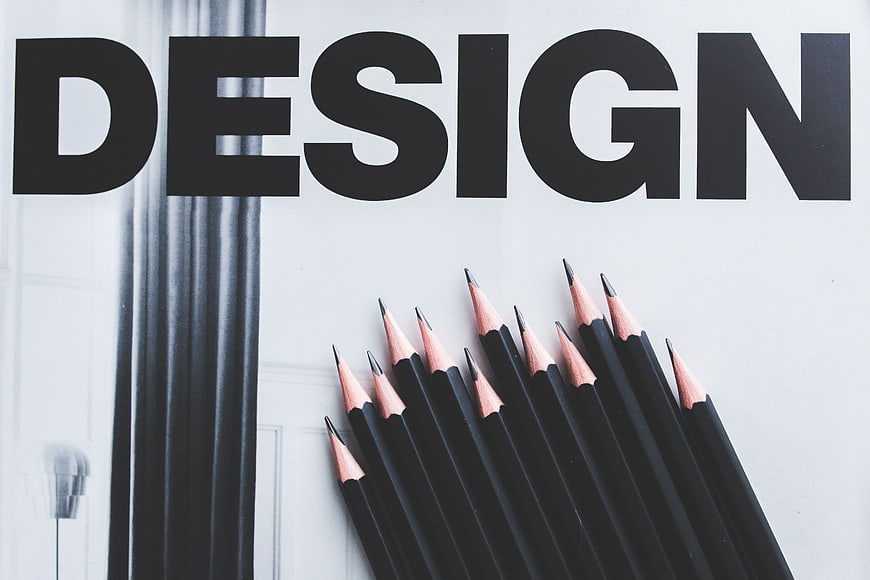 Black pencils arranged below bold Design typography