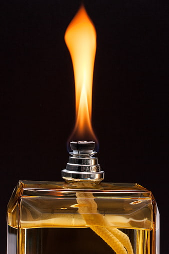 Close-up of burning oil lamp with golden flame