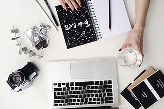 Flat Lay Workspace with Laptop, Camera, and Notebook