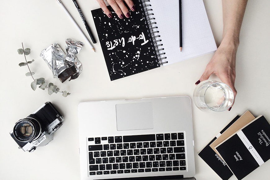 Flat Lay Workspace with Laptop, Camera, and Notebook