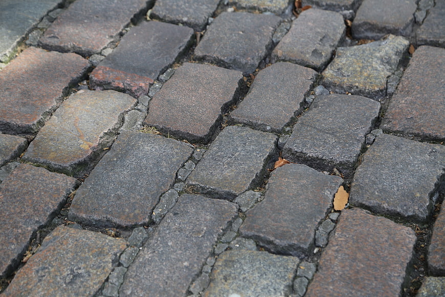 Close-up of weathered cobblestone pavement texture