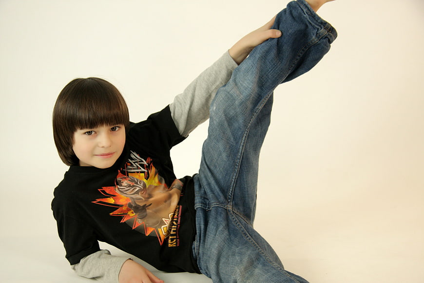 Young boy performing high kick martial arts pose