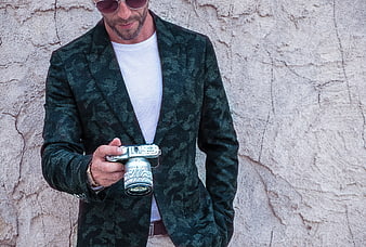 Stylish Man in Green Blazer Holding Camera