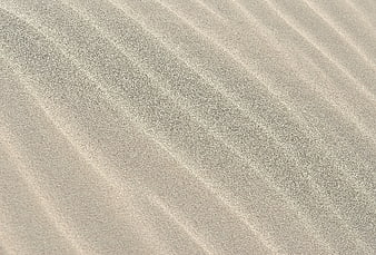 Close-up texture of rippled sand dunes with natural patterns