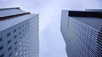 Low angle view of modern skyscrapers against cloudy sky