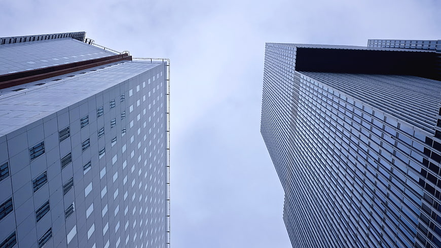 Low angle view of modern skyscrapers against cloudy sky