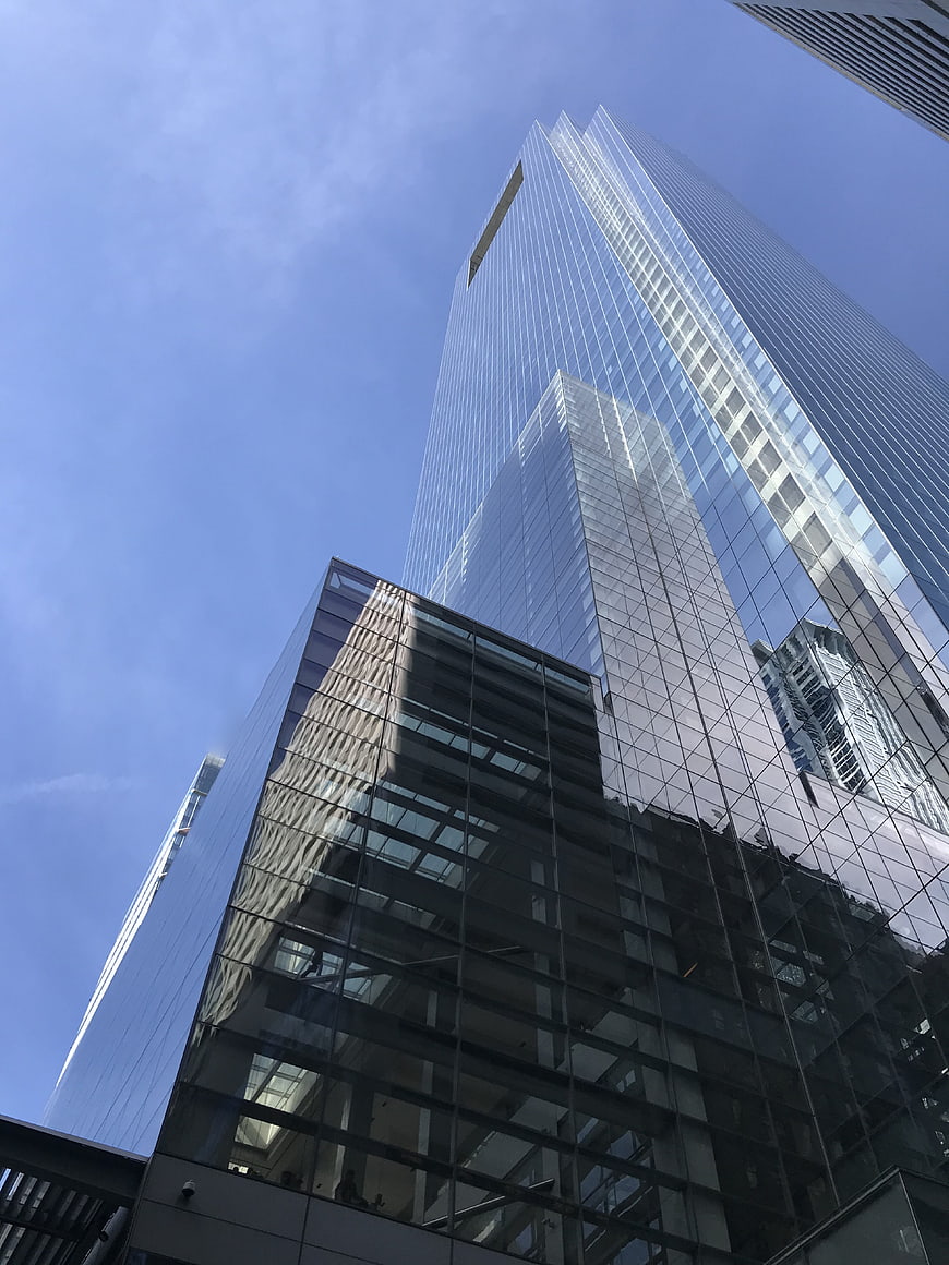 Low angle view of modern glass skyscrapers against blue sky