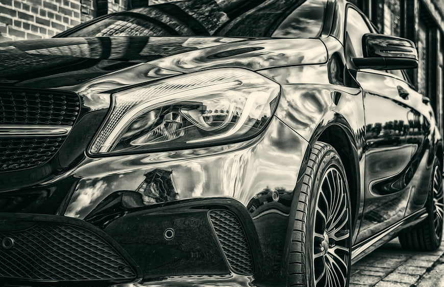 Close-up of black Mercedes-Benz front headlight and grille