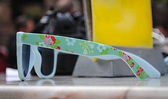 Side view of floral pattern children's sunglasses on a table