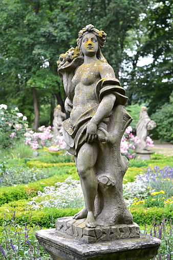 Weathered Stone Statue of Goddess in Lush Garden