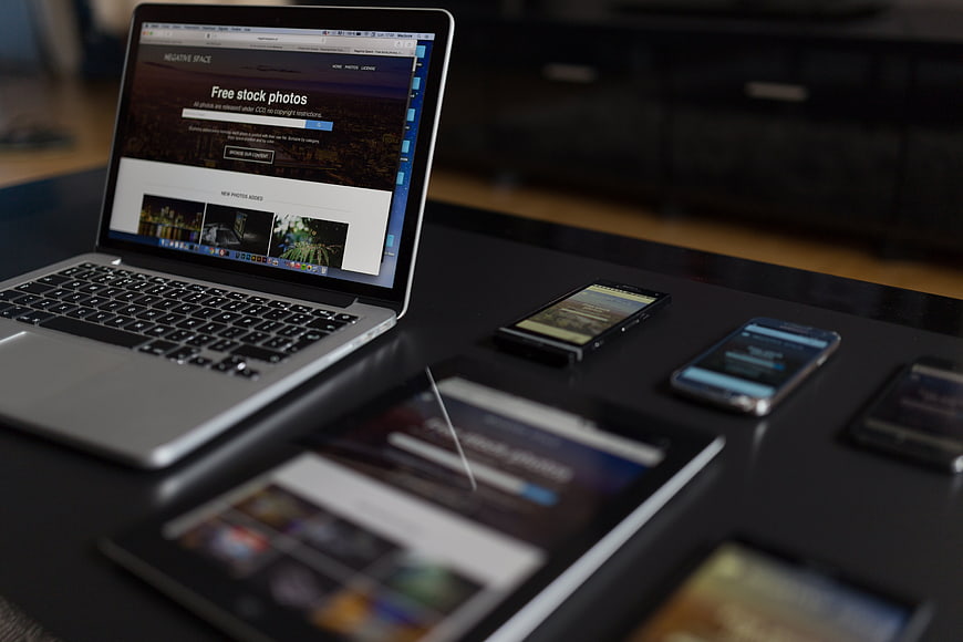 Laptop, tablet, and smartphones displaying website on desk