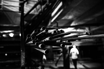 Black and white industrial steel pipes in warehouse