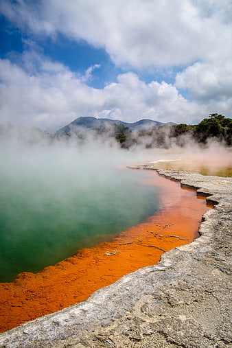 Steaming Geothermal Hot Spring with Orange Mineral Deposits