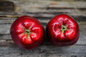 Two Fresh Red Apples on Rustic Wooden Surface