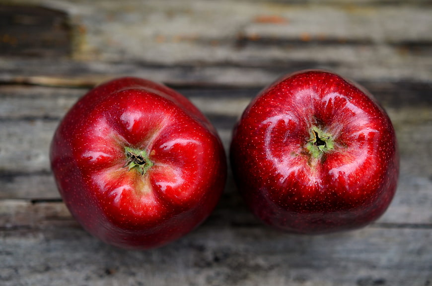 Two Fresh Red Apples on Rustic Wooden Surface