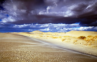Dramatic Storm Clouds Over Golden Sand Dunes