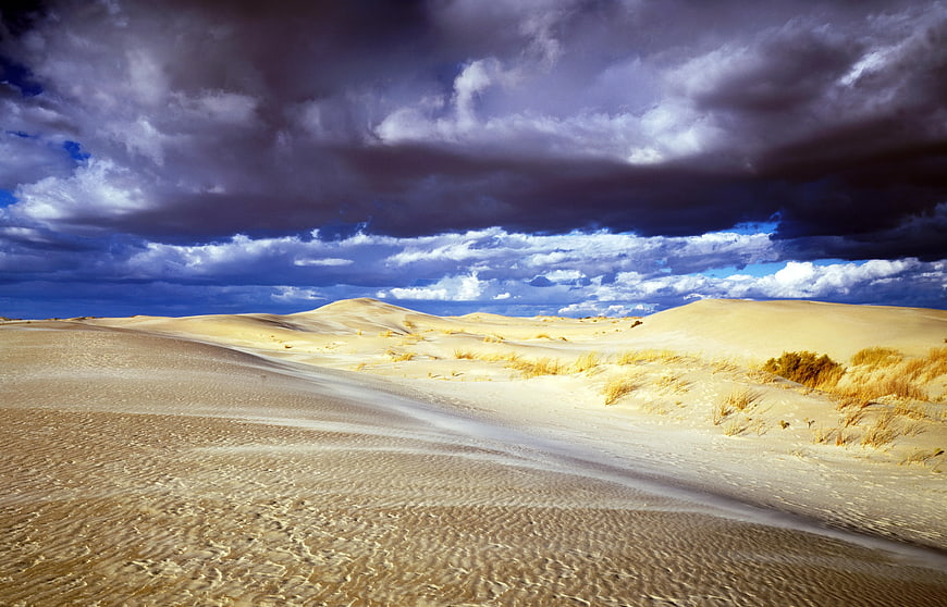 Dramatic Storm Clouds Over Golden Sand Dunes