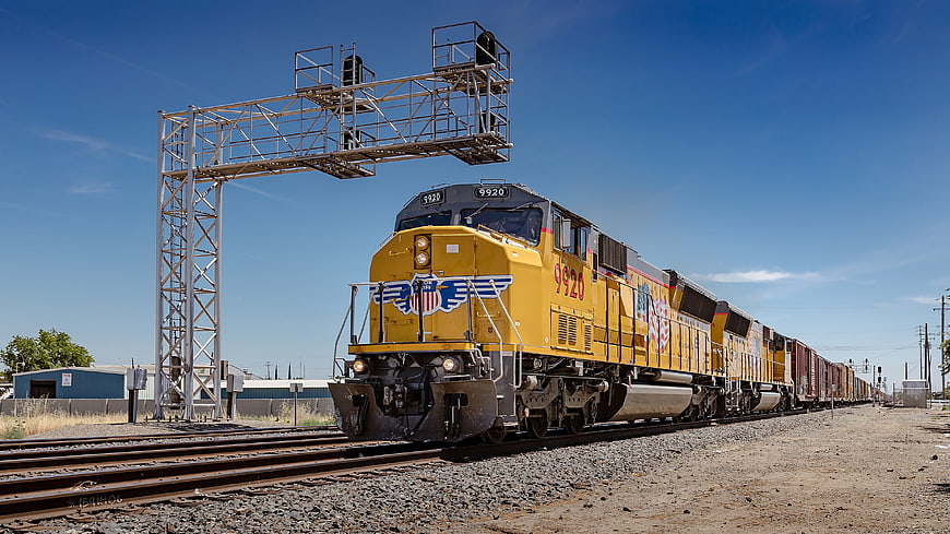 Yellow Union Pacific Freight Train Passing Railroad Signal Tower