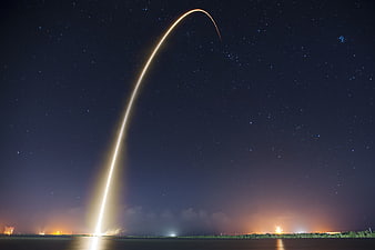 Long Exposure Rocket Launch Trail Against Starry Night Sky