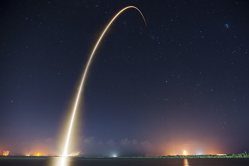 Long Exposure Rocket Launch Trail Against Starry Night Sky