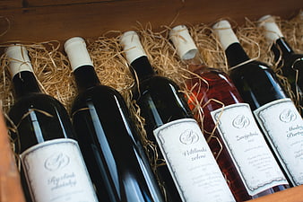 Assorted wine bottles in wooden crate with straw