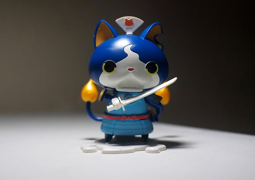 Blue Anime Cat Warrior Figurine Holding Sword On White Surface