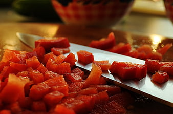 Close-up of diced red peppers on a chef's knife