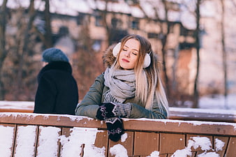 Relaxed Woman in Winter Clothes on Snowy Bridge
