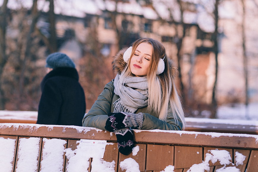 Relaxed Woman in Winter Clothes on Snowy Bridge