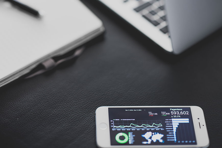 Smartphone displaying analytics dashboard on desk