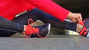 Runner tying shoelaces on wooden steps before workout