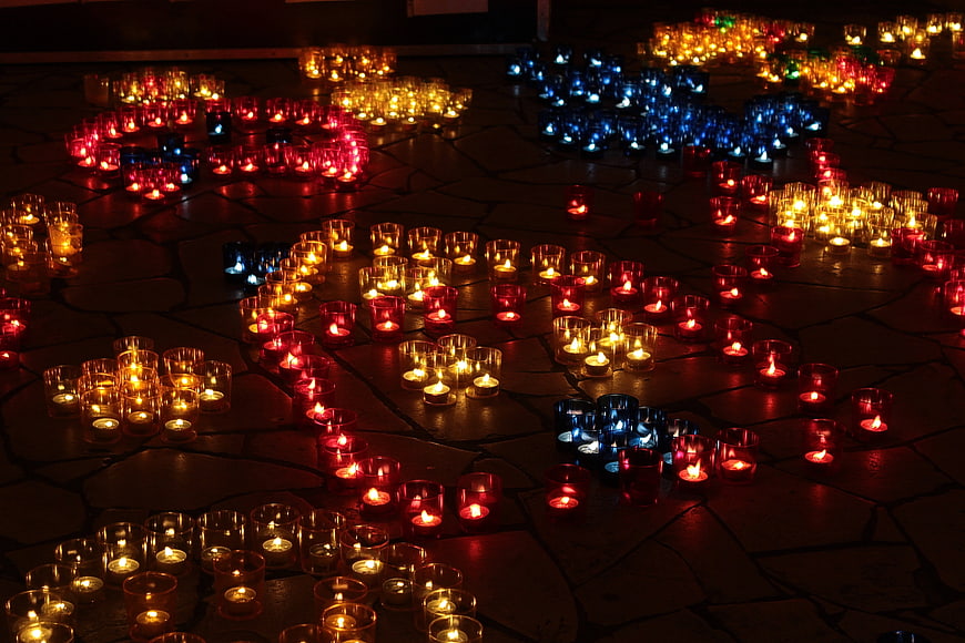 Colorful Tea Light Candles Arranged on Stone Floor