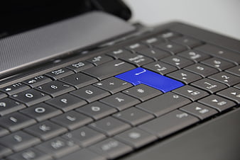 Close-up of laptop keyboard with blue enter key