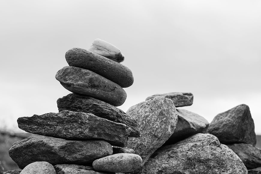 Black and white stacked stone cairn on a rocky landscape